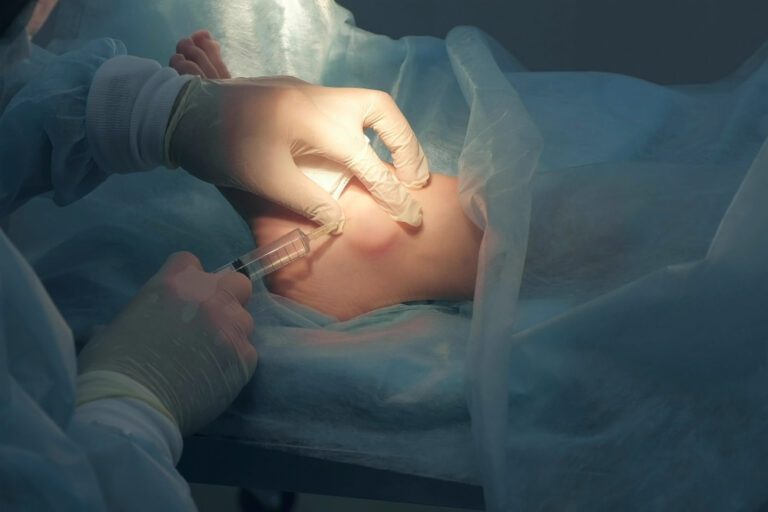 Profissional médico aplicando injeção em corpo de paciente.